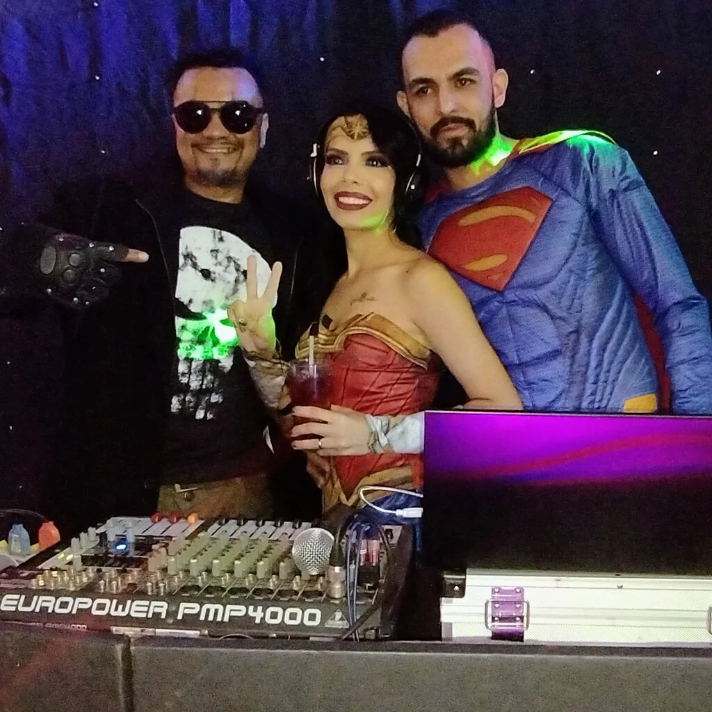 DJ Roger em foto com convidados fantasiados de mulher maravilha e superman